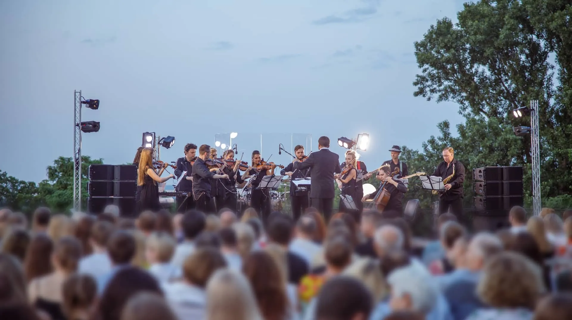 Firmenveranstaltung am Abend: Orchester spielt unter freiem Himmel vor Gästen