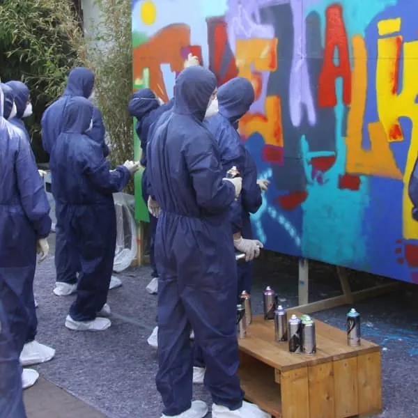 Teambuilding mit Montblanc: Team in Schutzanzügen sprüht ein Graffiti